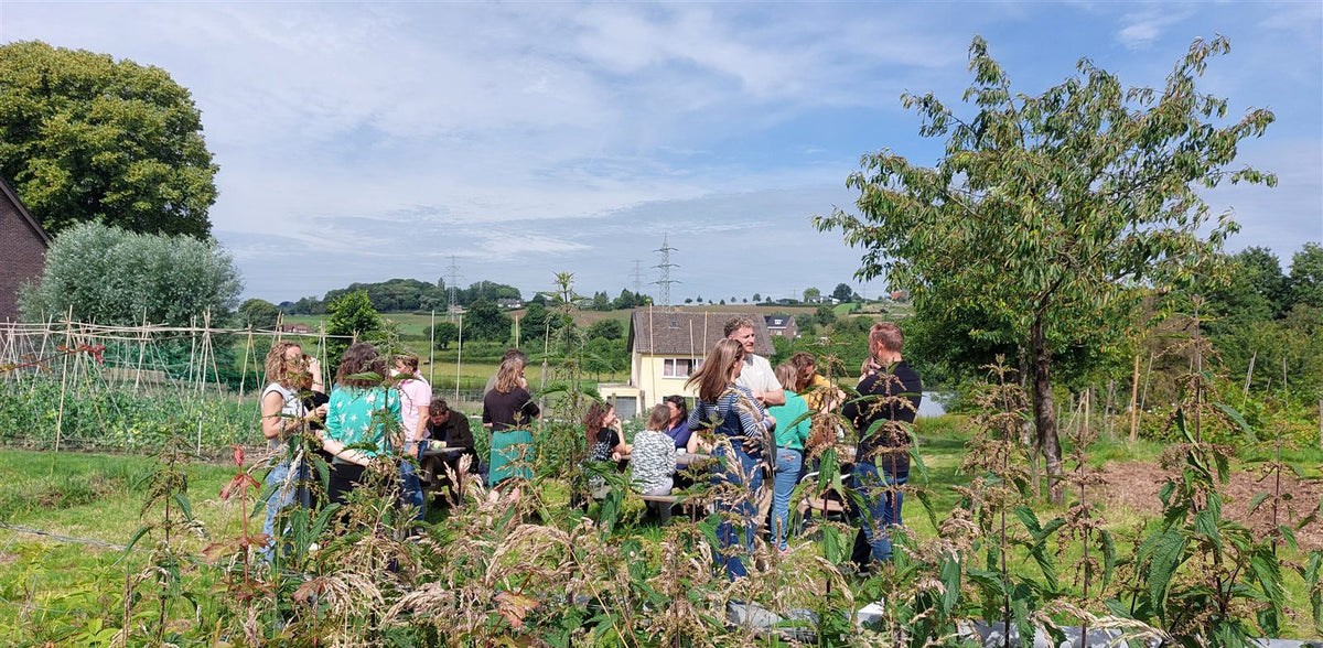 Een groep aan tafel in de moestuin van Lubosch Land